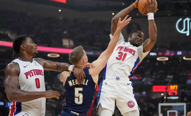 Detroit Pistons guard Javonte Green (31) grabs a rebound in front of Cleveland Cavaliers guard Sam Merrill (5) and teammate Jalen Duren (0) half of Game 3 of a second-round NBA playoffs basketball series Saturday, May 9, 2026 in Cleveland. (AP Photo/Sue Ogrocki)