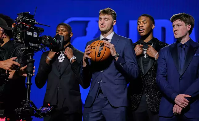 FILE - Cooper Flagg, center, poses for the camera along with Cedric Coward, far left, Thomas Sorber, second from right, and Kon Knueppel before the start of the first round of the NBA basketball draft, June 25, 2025, in New York. (AP Photo/Adam Hunger, File)