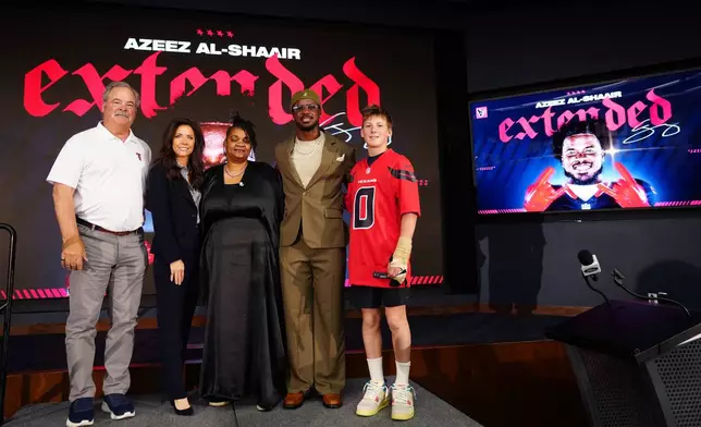 Houston Texans' Azeez Al-Shaair with his mother, Naadhirah Lennon, center, and Texan's owner Cal McNair, his wife, Hannah and their son, Calhoun McNair, far right, pose during a press conference at the NFL football team's facility, Friday, May 1, 2026, in Houston. (AP Photo/Karen Warren)