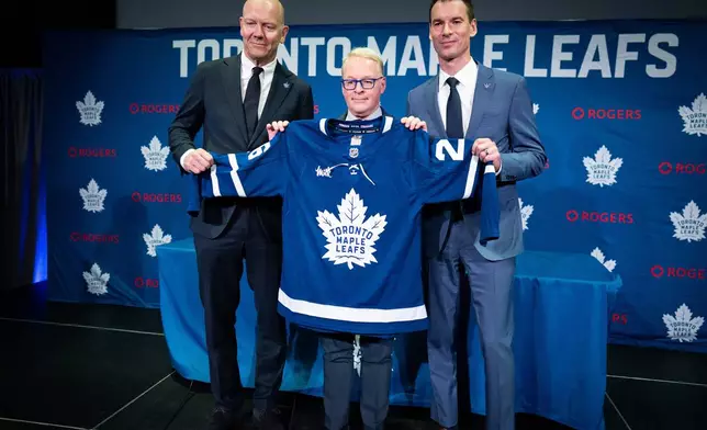 New Toronto Maple Leafs Senior Executive Advisor, Hockey Operations Mats Sundin, left to right, MLSE President and CEO Keith Pelley, and new Toronto Maple Leafs General Manager John Chayka, hold up a jersey following a press conference in Toronto on Monday, May 4, 2026. (Arlyn McAdorey/The Canadian Press via AP)