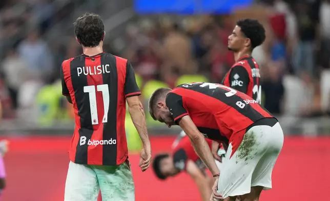 AC Milan's Christian Pulisic, left, reacts with his teammates Strahinja Pavlovic, center, and Zachary Athekame at the end of the Serie A soccer match between AC Milan and Cagliari, in Milan, Italy, Sunday, May 24, 2026. (AP Photo/Antonio Calanni)