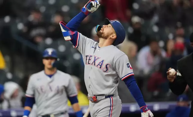 Texas Rangers' Brandon Nimmo gestures as he crosses home plate after hitting a two-run home run off Colorado Rockies relief pitcher Tanner Gordon in the fourth inning of a baseball game Tuesday, May 19, 2026, in Denver. (AP Photo/David Zalubowski)