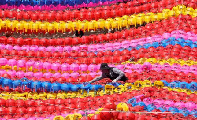 A work adjusts lanterns for upcoming celebration of Buddha's birthday on May 24 at Jogye temple in Seoul, South Korea, Friday, April 24, 2026. (AP Photo/Ahn Young-joon)