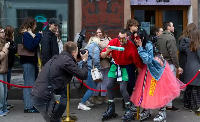 Street performers pose for a photographer at Old Town in Vilnius, Lithuania, Friday, April 24, 2026. (AP Photo/Mindaugas Kulbis)