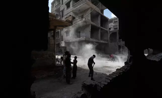 Residents remove rubble from damaged buildings in the al-Hajar al-Aswad neighborhood on the outskirts of Damascus, Syria, Wednesday, April 29, 2026 in a area that was heavily bombed by forces loyal to former Syrian President Bashar Assad during the Syrian war. (AP Photo/Omar Sanadiki)