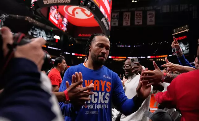 New York Knicks guard Jalen Brunson (11) high fives fans as he leaves the court in the second half during Game 6 in a first-round NBA basketball playoffs series Thursday, April 30, 2026, in Atlanta. (AP Photo/Brynn Anderson)