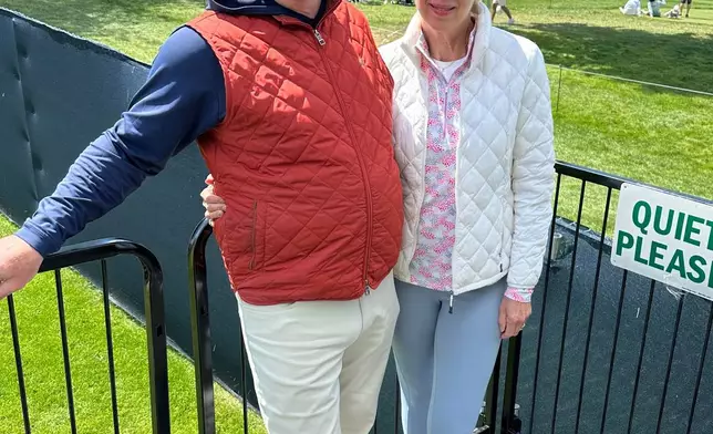 Jim Hageney, left, and his wife Eileen Hageney watch the PGA Championship golf tournament from a rented platform in their backyard outside the Aronimink Golf Club, Friday, May 15, 2026 in Newtown Square, Pa. (AP Photo/Dan Gelston)