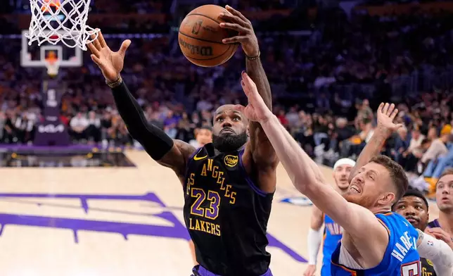 Los Angeles Lakers forward LeBron James, left, grabs a rebound away from Oklahoma City Thunder center Isaiah Hartenstein during the first half of Game 4 in a second-round NBA basketball playoffs series Monday, May 11, 2026, in Los Angeles. (AP Photo/Mark J. Terrill)