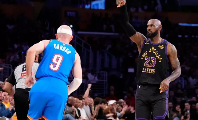 Los Angeles Lakers forward LeBron James, right, gestures after scoring as Oklahoma City Thunder guard Alex Caruso runs by during the first half of Game 4 in a second-round NBA basketball playoffs series Monday, May 11, 2026, in Los Angeles. (AP Photo/Mark J. Terrill)