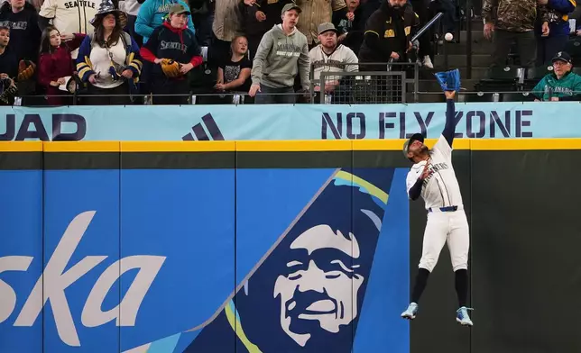 Seattle Mariners center fielder Julio Rodríguez makes a leaping grab of a long fly ball off the bat of San Diego Padres' Rodolfo Durán during the ninth inning of a baseball game, Saturday, May 16, 2026, in Seattle. (AP Photo/Lindsey Wasson)