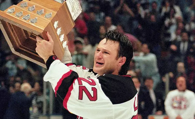 FILE - New Jersey Devils right wing Claude Lemieux holds the Conn Smythe Trophy after his team defeated the Detroit Red Wings 5-2 in Game 4 of the Stanley Cup Finals to win the championship Saturday night, June 24, 1995 at the Meadowlands Arena in East Rutherford, N.J.(AP Photo/Bill Kostroun, File)