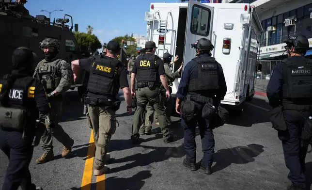 Drug Enforcement Administration (DEA) agents alongside other law enforcement officers work the scene near MacArthur Park after federal authorities made arrests on charges related to selling illicit drugs on Wednesday, May 6, 2026, in Los Angeles. (AP Photo/Jae C. Hong)