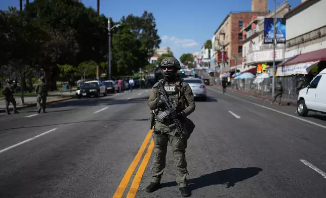 A law enforcement officer stands on a street near MacArthur Park after federal authorities made arrests on charges related to selling illicit drugs on Wednesday, May 6, 2026, in Los Angeles. (AP Photo/Jae C. Hong)
