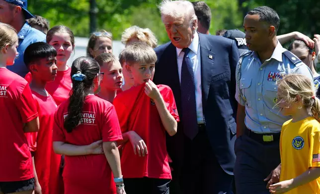 President Donald Trump walks with kids during exercise drills on the south lawn of the White House, Tuesday, May 5, 2026, in Washington. (AP Photo/Jacquelyn Martin)