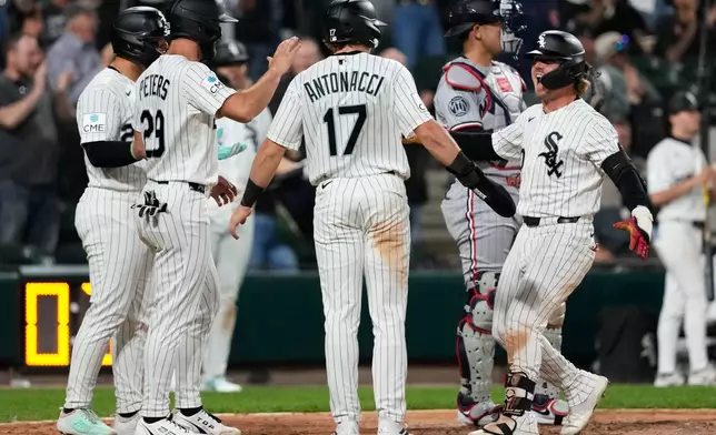 Chicago White Sox's Chase Meidroth, right, celebrates with Edgar Quero, left, Tristan Peters (29) and Sam Antonacci (17) after hitting a grand slam during the seventh inning of a baseball game against the Minnesota Twins in Chicago, Wednesday, May 27, 2026. (AP Photo/Nam Y. Huh)