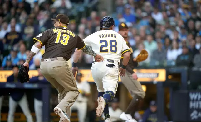 San Diego Padres third baseman Manny Machado (13) tags out Milwaukee Brewers' Andrew Vaughn (28) during the first inning of a baseball game, Thursday, May 14, 2026, in Milwaukee. (AP Photo/Kayla Wolf)
