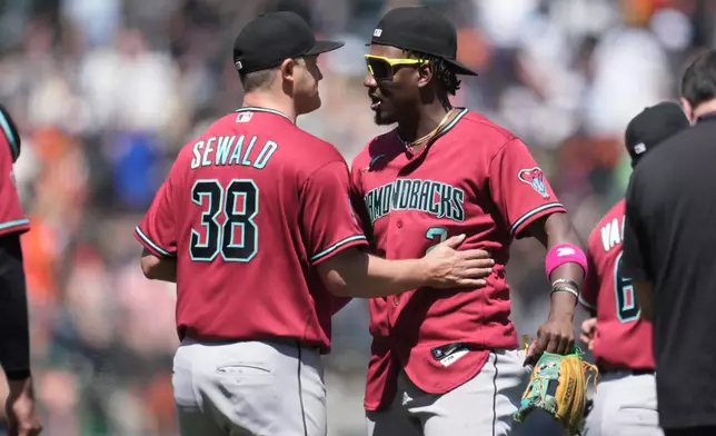 Arizona Diamondbacks' Paul Sewald (38) and Geraldo Perdomo celebrate after a baseball game against the San Francisco Giants Wednesday, May 27, 2026, in San Francisco. (AP Photo/Jeff Chiu)