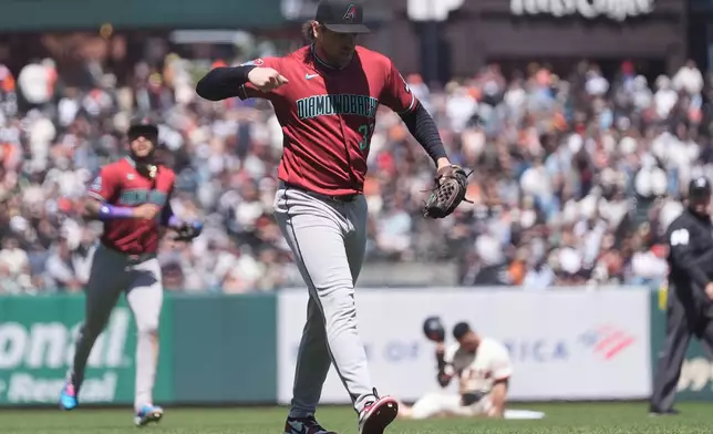Arizona Diamondbacks pitcher Kevin Ginkel, middle, reacts after picking off San Francisco Giants' Luis Arraez, bottom rear, for the final out of the eighth inning of a baseball game Wednesday, May 27, 2026, in San Francisco. (AP Photo/Jeff Chiu)