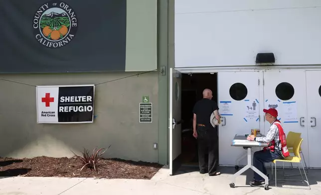People arrive at Freedom Hall, an evacuation center in Fountain Valley, Calif., after a storage tank containing a chemical used to make plastic parts overheated Thursday at an aerospace plastics facility in Garden Grove, on Saturday, May 23, 2026. (AP Photo/Jill Connelly)