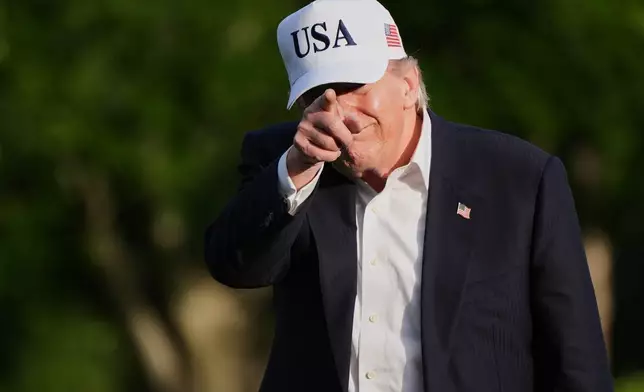 President Donald Trump gestures to reporters as he walks across the South Lawn of the White House, Friday, May 15, 2026, in Washington, on return from Beijing where he met with China's President Xi Jinping. (AP Photo/Jacquelyn Martin)