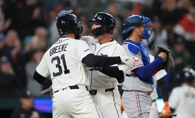 Detroit Tigers' Spencer Torkelson, center celebrates his two-run home run with Riley Greene (31) as Texas Rangers catcher Kyle Higashioka, right, looks on during the fifth inning of a baseball game Sunday, May 3, 2026, in Detroit. (AP Photo/Paul Sancya)