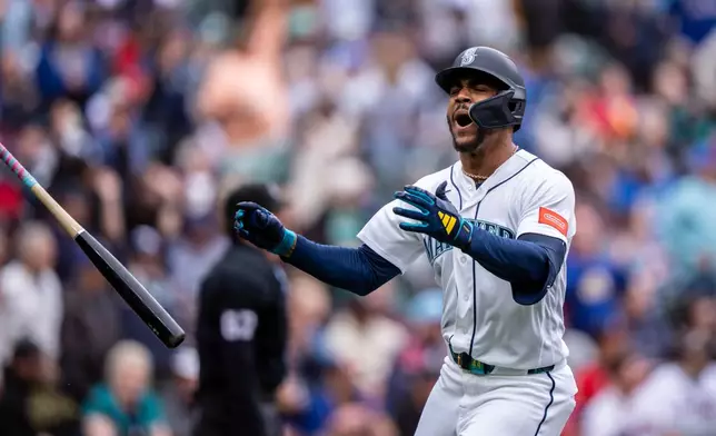 Seattle Mariners' Julio Rodríguez tosses his bat and celebrates after hitting a solo home run during the sixth inning of a baseball game against the Atlanta Braves, Wednesday, May 6, 2026, in Seattle. (AP Photo/Stephen Brashear)
