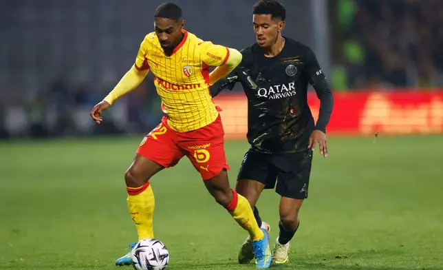 Lens' Wesley Said, left, challenges fro the ball with PSG's Senny Mayulu during the French League One soccer match between Lens and Paris Saint Germain, in Lens, northern France, Wednesday, May 13, 2026. (AP Photo/Jean-Francois Badias)