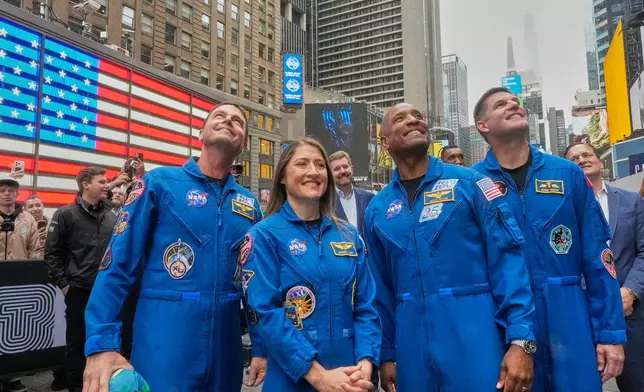From left, NASA's Artemis II astronauts Reid Wiseman, Christina Koch, Victor Glover, and Jeremy Hansen watch a replay of their ringing of the closing bell at the Nasdaq MarketSite, in New York's Times Square, Thursday, April 30, 2026. (AP Photo/Richard Drew)
