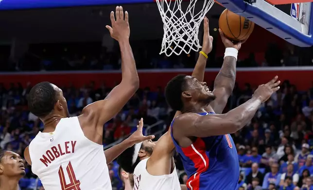 Detroit Pistons center Jalen Duren lays up a shot against Cleveland Cavaliers center Jarrett Allen, center, and center Evan Mobley (4) during the first half in Game 5 of a second-round NBA playoffs basketball series, Wednesday, May 13, 2026, in Detroit. (AP Photo/Duane Burleson)