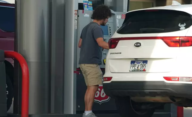 A motorist fills up the tank of a utility vehicle at a Phillips 66 gasoline station at Denver International Airport Saturday, May 9, 2026, in Denver. (AP Photo/David Zalubowski)