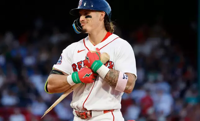 Boston Red Sox player Jarren Duran hugs his broken bat after breaking it on a single during the fourth inning of a baseball game against the Atlanta Braves, Wednesday, May 27, 2026, in Boston. (AP Photo/Mary Schwalm)