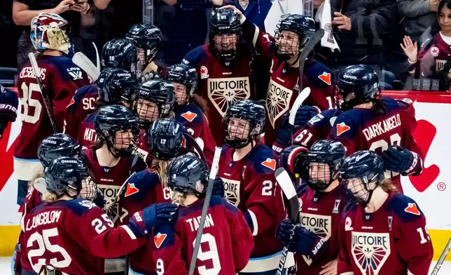 Montreal Victoire players celebrate after Maggie Flaherty (91), top center, scored scored the game winning goal against Ottawa Charge during overtime in Game 2 of the PWHL Walter Cup finals hockey series in Laval, Quebec, Saturday, May 16, 2026. (Christopher Katsarov/The Canadian Press via AP)