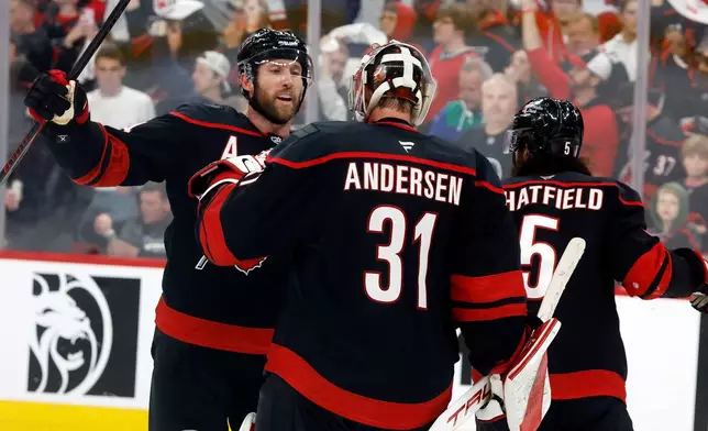 Carolina Hurricanes goaltender Frederik Andersen (31) is congratulated by Jaccob Slavin, left, following Game 1 of an NHL hockey Stanley Cup second-round playoff series against the Philadelphia Flyers in Raleigh, N.C., Saturday, May 2, 2026. (AP Photo/Karl DeBlaker)