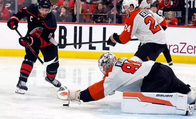 Carolina Hurricanes' Jordan Staal (11) lunges for the puck with Philadelphia Flyers goaltender Dan Vladar (80) and Nick Seeler (24) nearby during the second period of Game 1 of an NHL hockey Stanley Cup second-round playoff series in Raleigh, N.C., Saturday, May 2, 2026. (AP Photo/Karl DeBlaker)