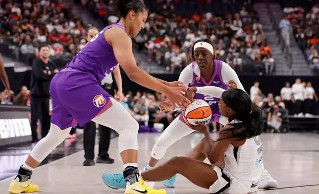 Phoenix Mercury forward Alyssa Thomas, left, and guard/forward Kahleah Copper, back right, defend against Las Vegas Aces guard Jackie Young, front right, during the first half of an WNBA basketball game Saturday, May 9, 2026, in Las Vegas. (Steve Marcus/Las Vegas Sun via AP)