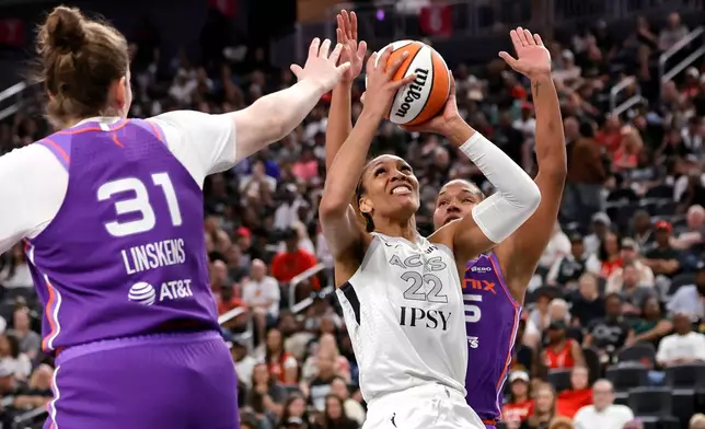 Las Vegas Aces center A'ja Wilson (22) looks to shoot between Phoenix Mercury center Kyara Linskens (31) and forward Alyssa Thomas, right, during the first half of an WNBA basketball game Saturday, May 9, 2026, in Las Vegas. (Steve Marcus/Las Vegas Sun via AP)