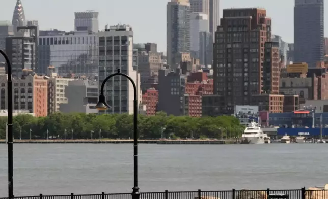 People lay out in the sun in front of the New York City skyline in Hoboken, N.J., Wednesday, May 20, 2026. (AP Photo/Seth Wenig)