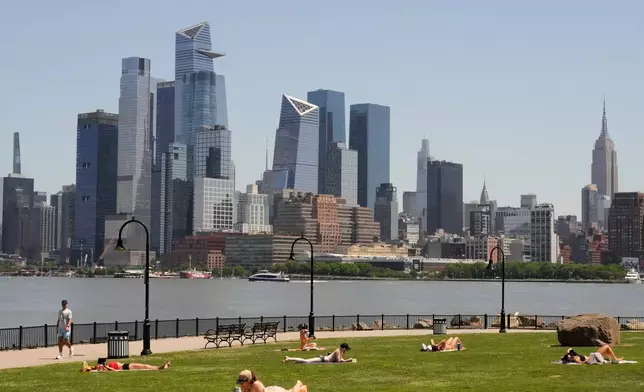 People lay out in the sun in front of the New York City skyline, in Hoboken, N.J., Wednesday, May 20, 2026. (AP Photo/Seth Wenig)