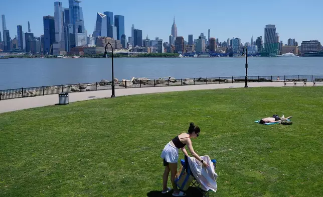 People lay out in the sun in front of the New York City skyline in Hoboken, N.J., Wednesday, May 20, 2026. (AP Photo/Seth Wenig)
