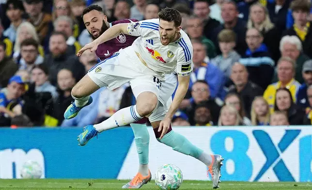 Leeds United's Anton Stach, front, is tackled from behind by Burnley's Quilindschy Hartman during the English Premier League soccer match between Leeds United and Burnley, Friday, May 1, 2026, in Leeds, England. (Martin Rickett/PA via AP)