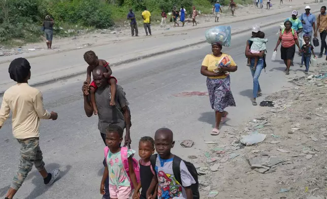 Residents flee their homes to escape clashes between armed gangs in Port-au-Prince, Haiti, Monday, May 11, 2026. (AP Photo/Odelyn Joseph)