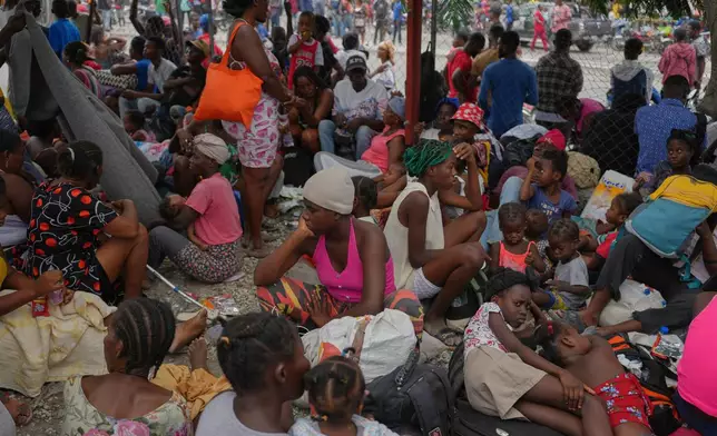 Residents flee their homes to escape clashes between armed gangs in Port-au-Prince, Haiti, Monday, May 11, 2026. (AP Photo/Odelyn Joseph)