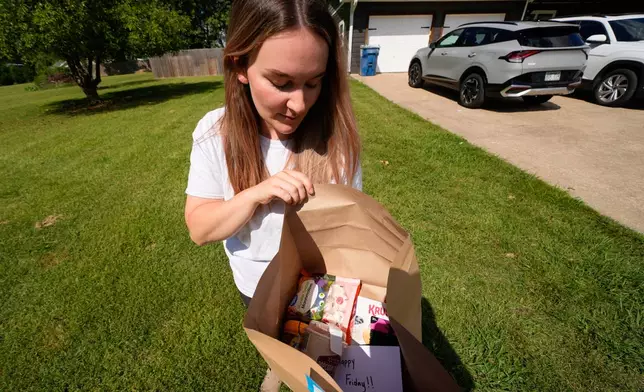 Emily Ingram checks her Walmart order after it was delivered by a drone operated by Zipline in Pea Ridge, Ark., Friday, Sept. 26, 2025. (AP Photo/Charlie Riedel)