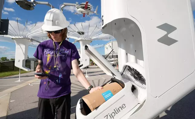 A Zipline employee loads a drone with an order at a Walmart store in Pea Ridge, Ark., Friday, Sept. 26, 2025. (AP Photo/Charlie Riedel)