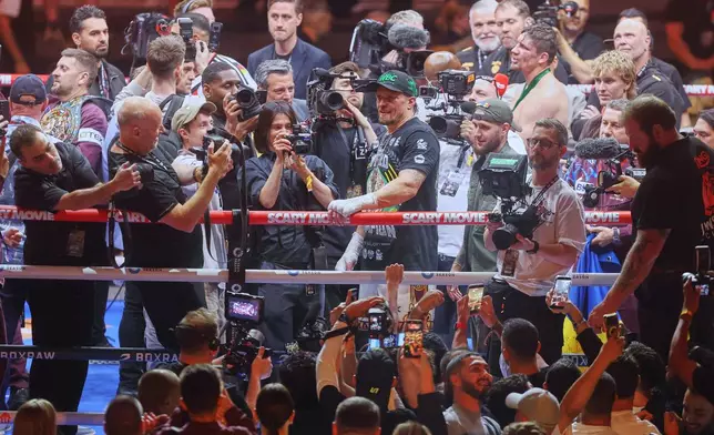 Oleksandr Usyk, center right, celebrates after winning his boxing match against Rico Verhoeven during the WBC World Heavyweight Championship "Glory in Giza" at the site of the Pyramids of Giza, Sunday, May 24, 2026, in Giza, Egypt. (AP Photo)