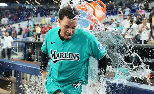 Miami Marlins' Heriberto Hernández is doused after hitting a walk-off grand slam during the ninth inning to defeat the New York Mets in a baseball game, Sunday, May 24, 2026, in Miami. (AP Photo/Lynne Sladky)