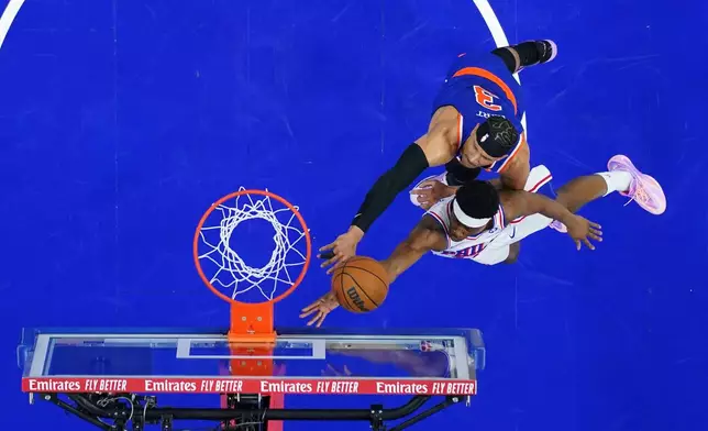 Philadelphia 76ers' Vj Edgecombe, bottom, goes up for a shot against New York Knicks' Josh Hart during the first half of Game 4 in a second-round NBA basketball playoffs series Sunday, May 10, 2026, in Philadelphia. (AP Photo/Matt Slocum)