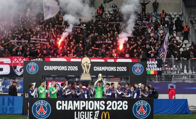 PSG's team players celebrate with the trophy after winning the French League One title, before the French League One soccer match between Paris FC and Paris Saint-Germain in Paris, Sunday, May 17, 2026. (AP Photo/Michel Euler)