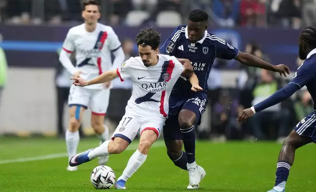 PSG's Vitinha, centre left, and Paris FC's Marshall Munetsi challenge for the ball during the French League One soccer match between Paris FC and Paris Saint-Germain in Paris, Sunday, May 17, 2026. (AP Photo/Michel Euler)