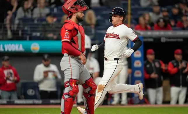 Cleveland Guardians' Petey Halpin, right, scores behind Los Angeles Angels catcher Sebastián Rivero, left, in the seventh inning of a baseball game in Cleveland, Tuesday, May 12, 2026. (AP Photo/Sue Ogrocki)